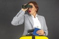 Happy beautiful business woman looking through binoculars towards her travels. Vacation and entertainment. Search for places to