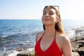 Happy beautiful carefree woman breathing fresh air enjoying wind on the beach. Relaxed bikini woman with closed eyes feeling good Royalty Free Stock Photo