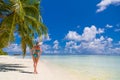 Happy beautiful carefree woman enjoying sunshine on the beach. Young woman in red pink bikini in white sandy beach at Maldive Royalty Free Stock Photo