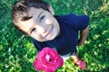 Happy beautiful child on ground with rose outdoor