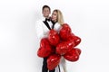 Happy beautiful couple posing on white background and holding balloons heart. Valentine`s day. Royalty Free Stock Photo