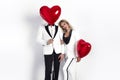 Happy beautiful couple posing on white background and holding balloons heart. Valentine`s day. Royalty Free Stock Photo