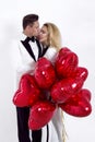 Happy beautiful couple posing on white background and holding balloons heart. Valentine`s day. Royalty Free Stock Photo