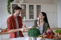 Happy beautiful couple preparing healthy food in the modern kitchen at home, laughing and having fun, enjoying free time Royalty Free Stock Photo