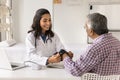 Happy beautiful doctor woman measuring blood pressure of senior patient Royalty Free Stock Photo