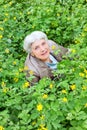 Happy beautiful elderly woman sitting on a glade Royalty Free Stock Photo