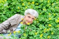 Happy beautiful elderly woman sitting on a glade Royalty Free Stock Photo