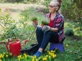 Happy beautiful elderly woman 60 years old working in her garden planting flowers Royalty Free Stock Photo