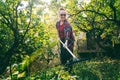 Happy beautiful senior woman 60 years old working in her garden using a rake. Garden care and an active lifestyle for retirees Royalty Free Stock Photo