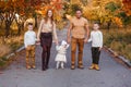 Happy beautiful family of five on walk in the autumn against the background of yellow leaves of mountain ash Royalty Free Stock Photo