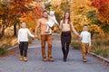 Happy beautiful family of five on walk in the autumn against the background of yellow leaves of mountain ash Royalty Free Stock Photo