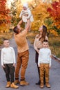 Happy beautiful family of five on walk in the autumn against the background of yellow leaves of mountain ash Royalty Free Stock Photo