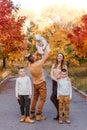 Happy beautiful family of five on walk in the autumn against the background of yellow leaves of mountain ash Royalty Free Stock Photo