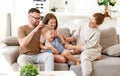 Happy beautiful family having fun and playing while relaxing on sofa in living room Royalty Free Stock Photo