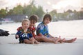 Happy beautiful fashion family, children, dressed in hawaiian shirts, playing together on the beach on sunset Royalty Free Stock Photo