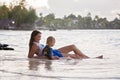 Happy beautiful fashion family, children, dressed in hawaiian shirts, playing together on the beach on sunset Royalty Free Stock Photo