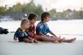 Happy beautiful fashion family, children, dressed in hawaiian shirts, playing together on the beach on sunset Royalty Free Stock Photo