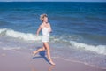 Happy beautiful free woman running on the beach jumping playful