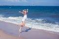 Happy beautiful free woman running on the beach jumping playful