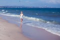 Happy beautiful free woman running on the beach jumping playful