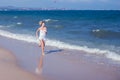 Happy beautiful free woman running on the beach jumping playful