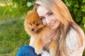 Happy beautiful gentle girl hugging her pet dog red Spitz