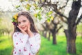 Happy beautiful girl enjoying blooming spring trees in apple orchard. Bulgarian woman in folklore dress on field Royalty Free Stock Photo