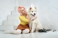 Happy beautiful girl and her big white dog sitting with pleasure in the arms. A beautiful young woman and her pet are best friends Royalty Free Stock Photo