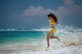 Happy beautiful girl runs and jumps in sea waves Royalty Free Stock Photo