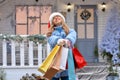 Happy beautiful girl with shopping bags in her hands against the background of the Christmas house,shop . Christmas, x-mas, Royalty Free Stock Photo