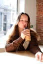 Happy beautiful girl sitting on stairs in park and drinking ice coffee cafe Royalty Free Stock Photo