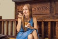 Happy beautiful girl sitting on stairs in park and drinking ice coffee Royalty Free Stock Photo