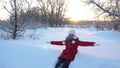 Happy beautiful girl smiles and falls in the snow. Winter games. Christmas holidays. Fun in cold climates