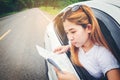 Happy beautiful girl traveling in a hatchback car with map Royalty Free Stock Photo