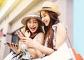 Happy Beautiful girls  holding shopping bags and watching the smart phone Royalty Free Stock Photo