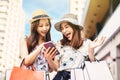 Happy Beautiful girls  holding shopping bags and watching the smart phone Royalty Free Stock Photo