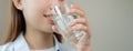 Happy beautiful, hand of asian young woman drinking, sip fresh glass of water for hydration of body, holding transparent glass in Royalty Free Stock Photo