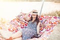 Happy beautiful hipster girl relaxing in hammock on the beach in summer evening light. joyful boho woman in straw hat resting and Royalty Free Stock Photo