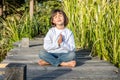 Happy beautiful kid doing yoga bare feet sitting on wood Royalty Free Stock Photo