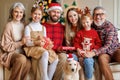 Happy beautiful large family with dog labrador retriever sitting on couch near decorated xmas tree Royalty Free Stock Photo