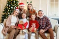 Happy beautiful large family with dog labrador retriever sitting on couch near decorated xmas tree Royalty Free Stock Photo