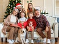 Happy beautiful large family with dog labrador retriever sitting on couch near decorated xmas tree Royalty Free Stock Photo