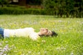 Happy beautiful latin woman lying on the green grass sleeping and meditating