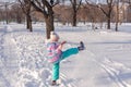 Happy beautiful little girl of seven eight years walking in winter snowy park