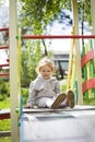 Happy beautiful little redhead girl climbs the slide on the playground