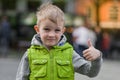 Happy little stylish blonde boy show ok sign, looking at camera