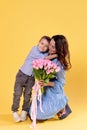 Happy beautiful mommy playing with cute little son indoors