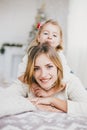 Happy beautiful mother and her little daughter posing near Christmas tree in a holiday interior Royalty Free Stock Photo