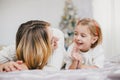 Happy beautiful mother and her little daughter posing near Christmas tree in a holiday interior Royalty Free Stock Photo