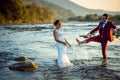 Happy beautiful newlywed couple having fun in the water while the groom is splashing water on his lovely bride Royalty Free Stock Photo